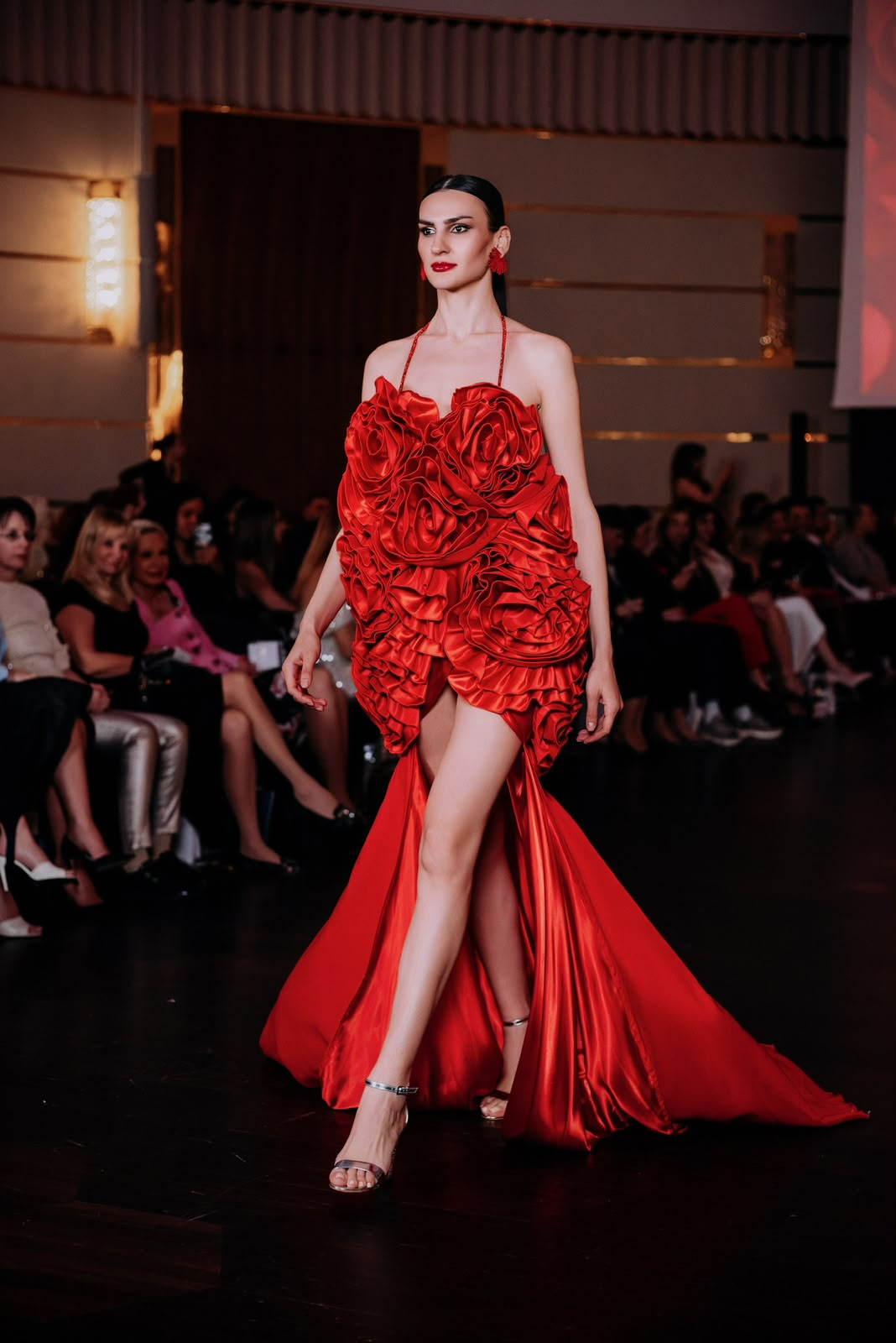 Model in a sculptural red rose couture gown on the Couture Fashion Night runway