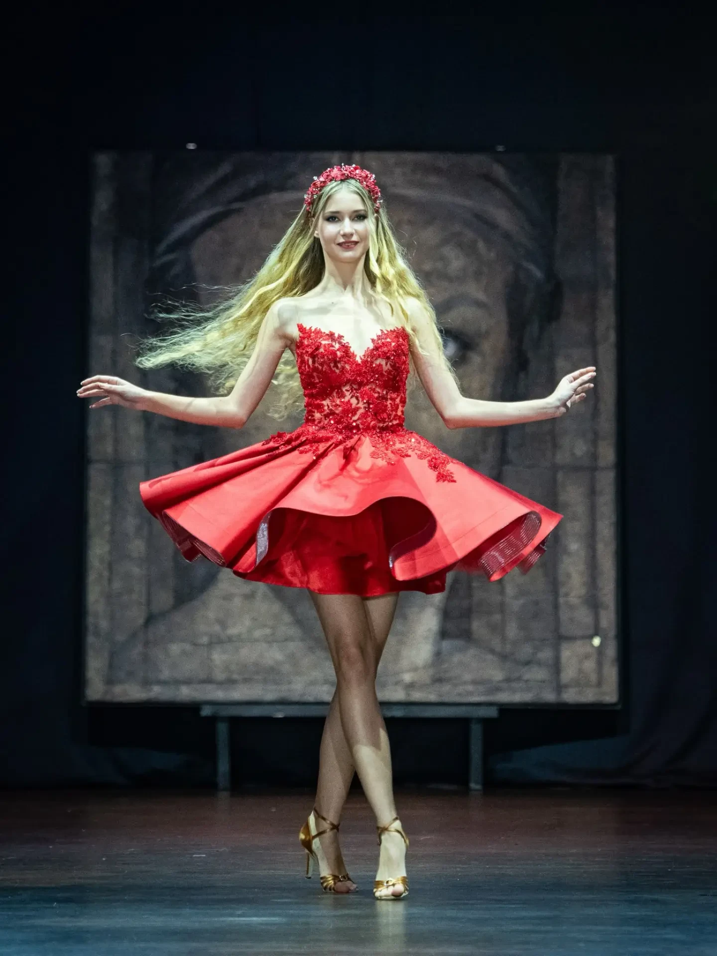 Model in a red embellished mini dress with a floral headpiece on the CFN 4.0 runway