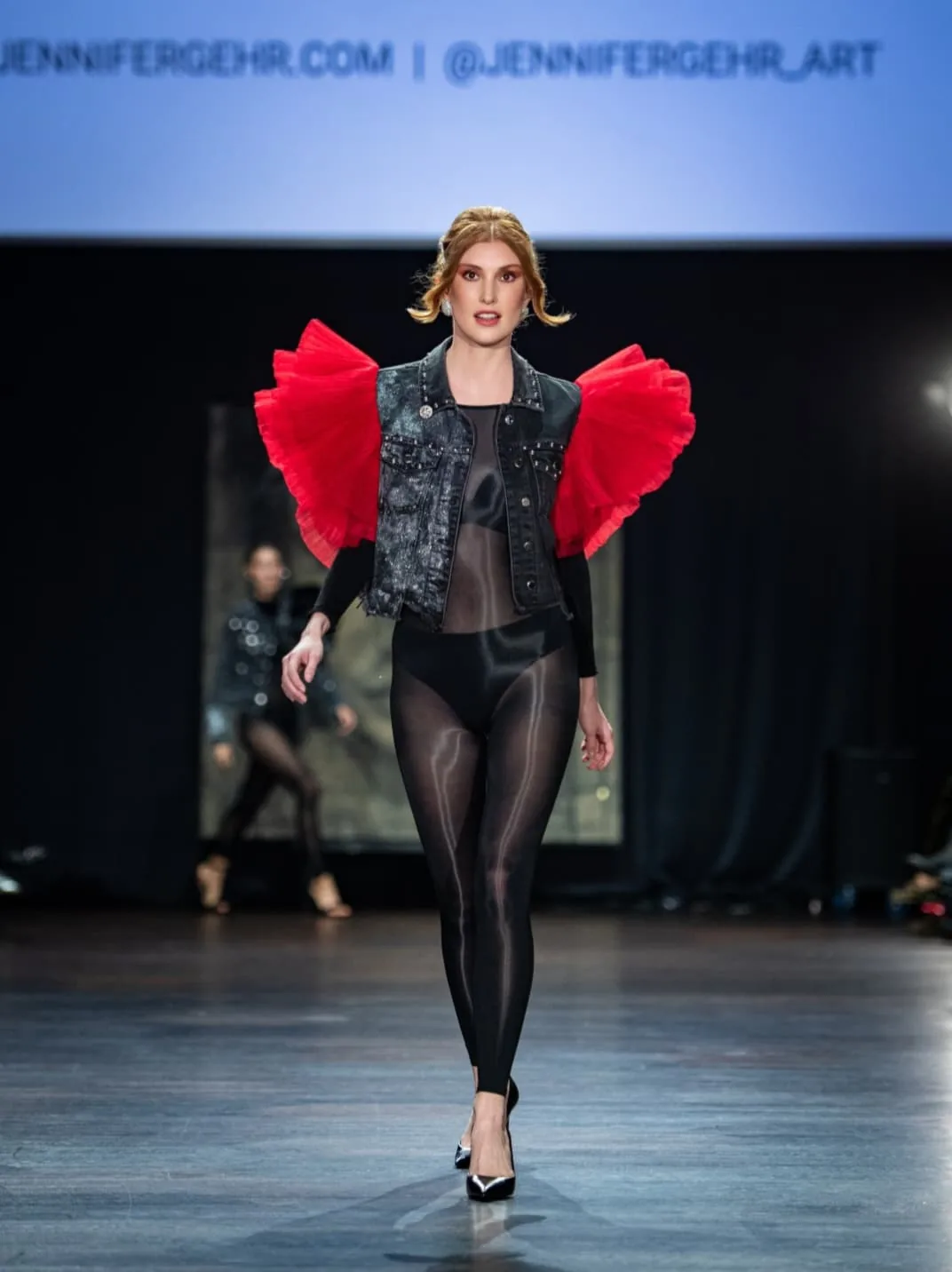 Model in a black denim Artjacket with red ruffled sleeves and a sheer black bodysuit by Jennifer Gehr on the CFN 4.0 runway