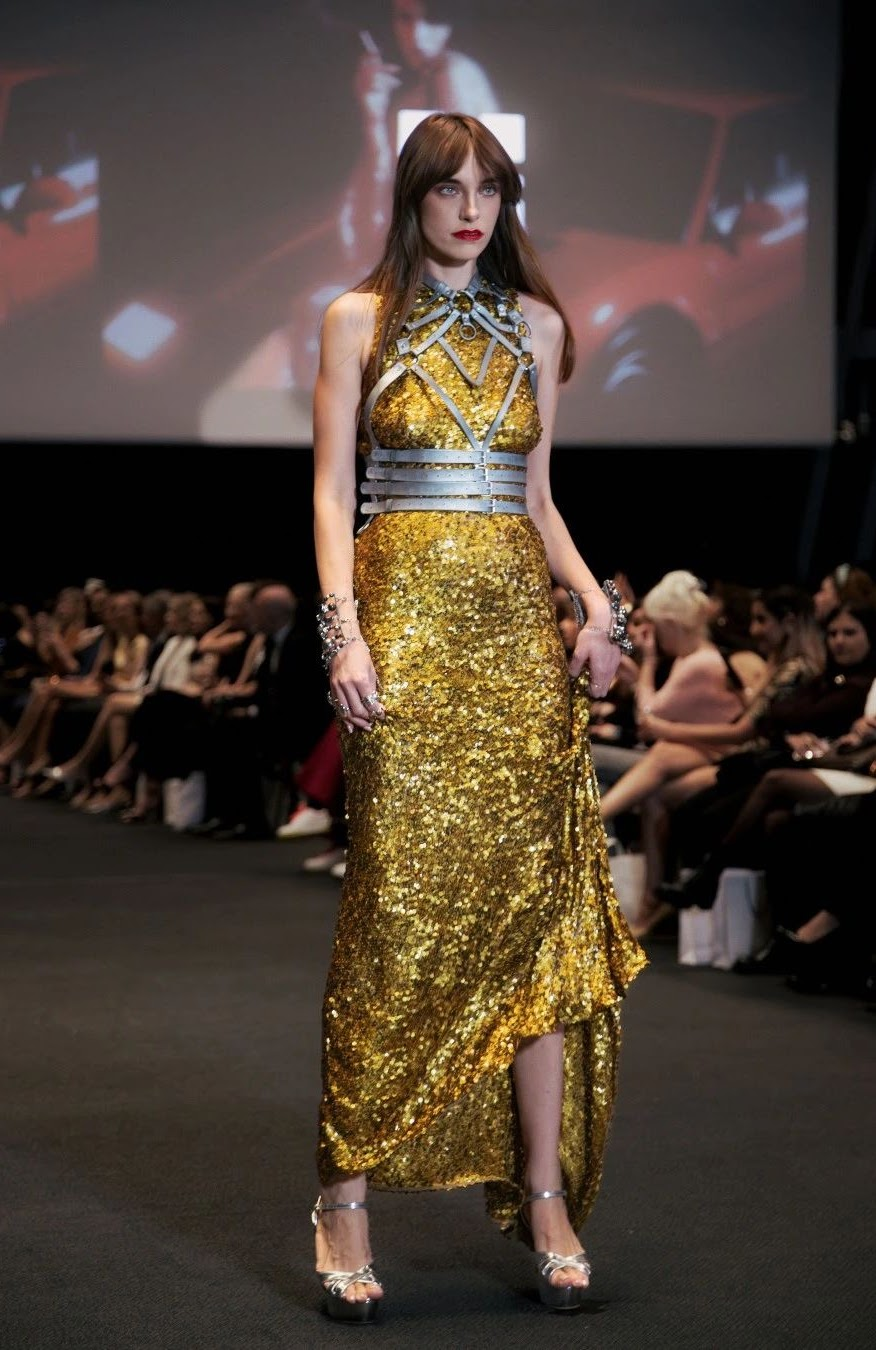 Model in a gold sequin couture gown with silver harness detailing on the Couture Fashion Night runway