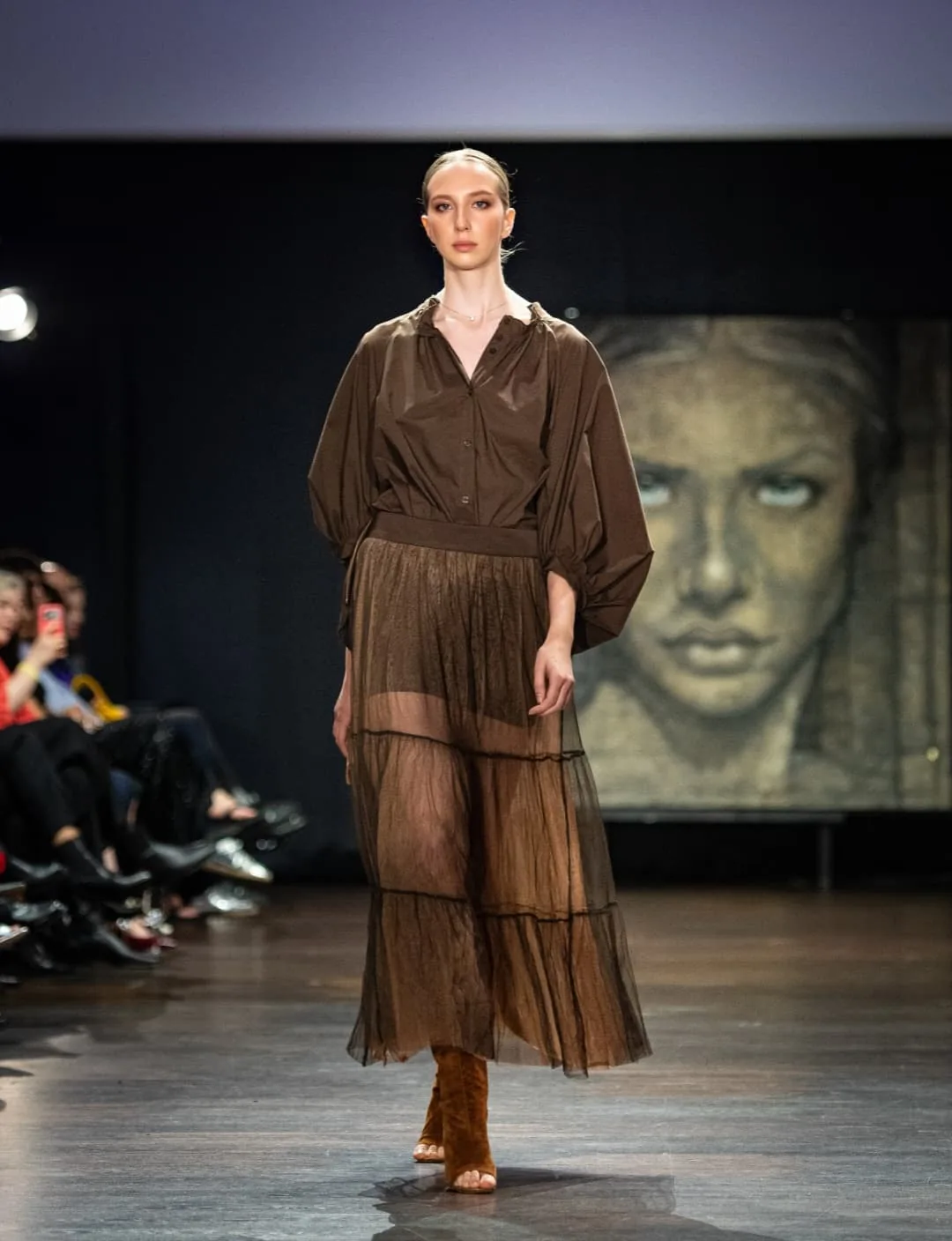 Model in a brown tiered sheer dress by SIERRA Zürich